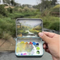 Pocket oil painting in a small tin palette held outdoors